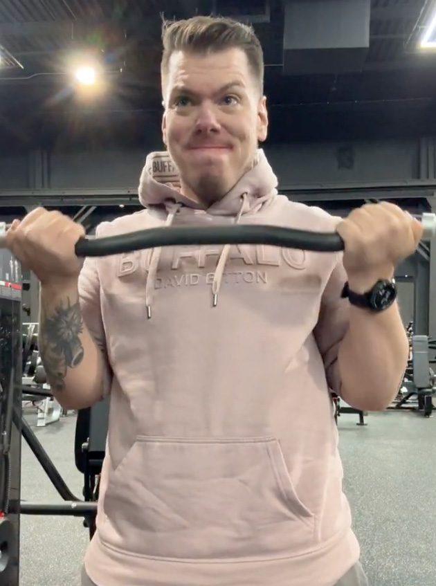 An image of Jesse doing bicep curls at the gym